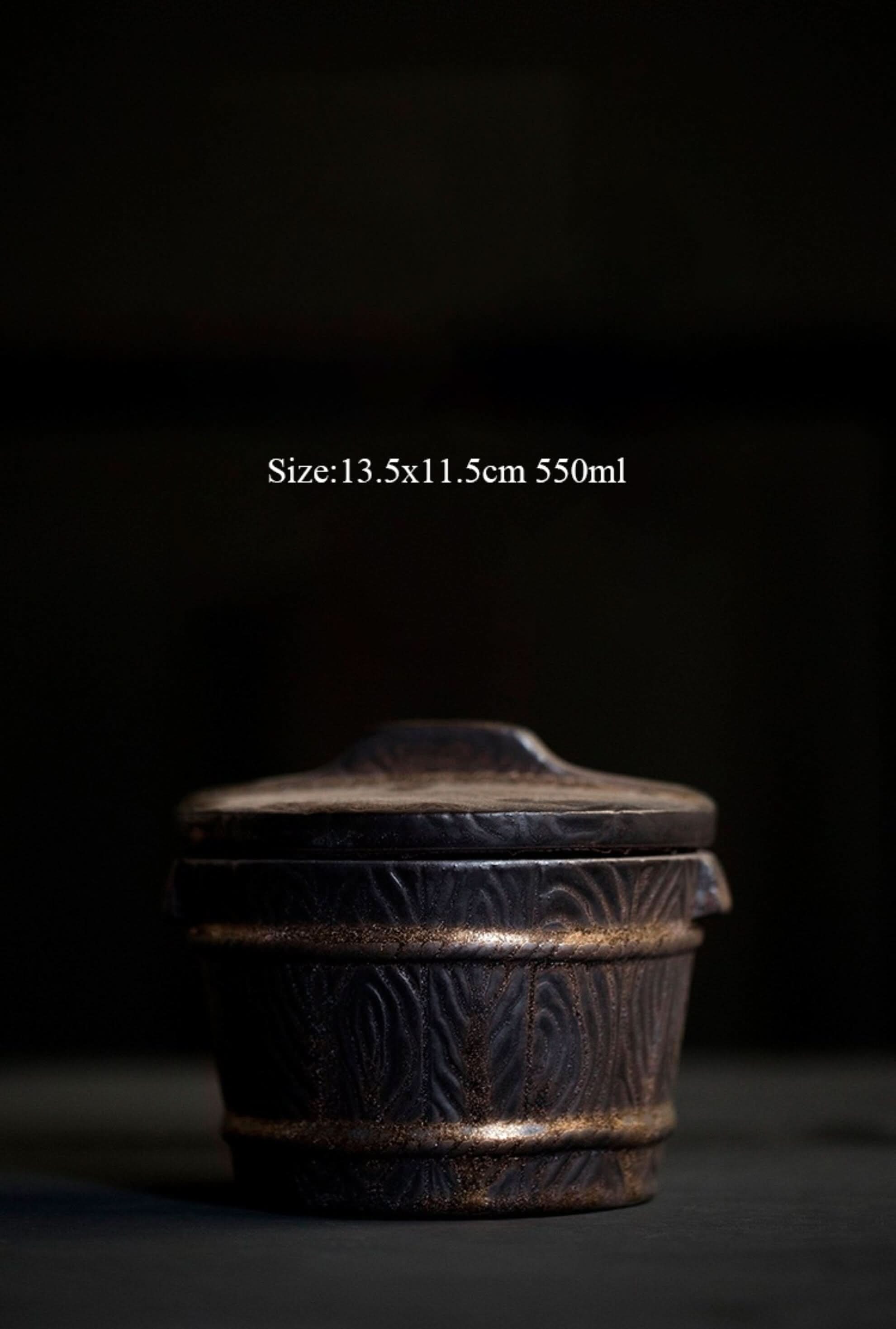 Dark ceramic Japanese tea jar with textured wood grain pattern and gold accent band.